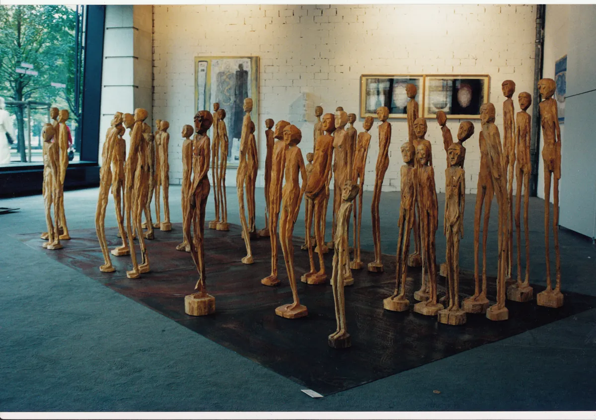 Die Skulpturengruppe Human Space mit vielen stelenartigen Holzfiguren, ausgestellt im Lindencorso in der Friedrichstraße in Berlin, 1998